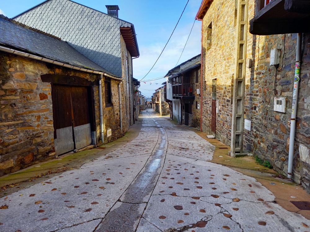 Pienen espanjalaisen kylän läpi johtava kivipäällysteinen tie Camino Norte reitillä.